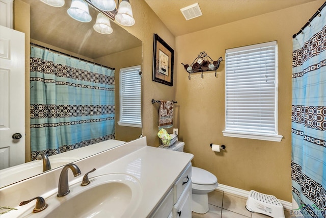 bathroom featuring tile patterned flooring, toilet, walk in shower, vanity, and a notable chandelier