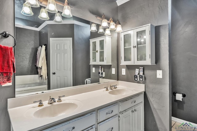 bathroom with ornamental molding, a washtub, tile patterned floors, and vanity