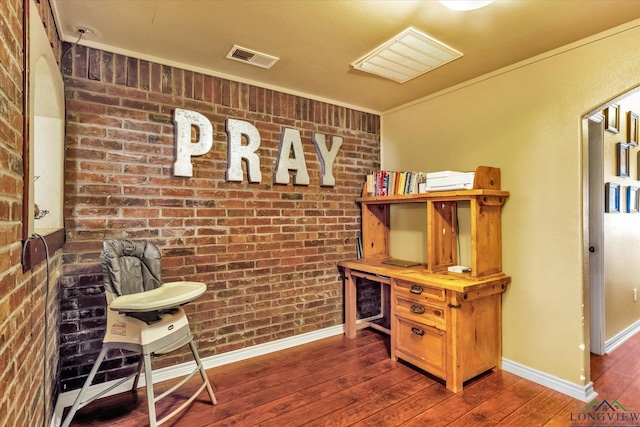 office with brick wall, dark hardwood / wood-style flooring, and crown molding