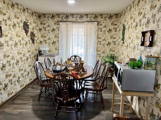 dining area featuring dark wood finished floors, baseboards, and wallpapered walls