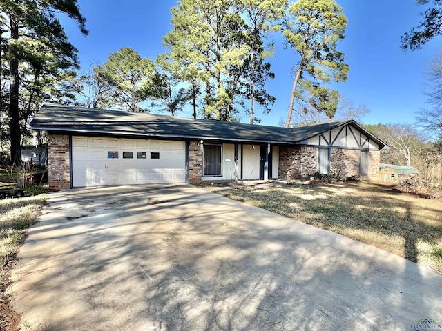 view of front of home with a garage, brick siding, and driveway