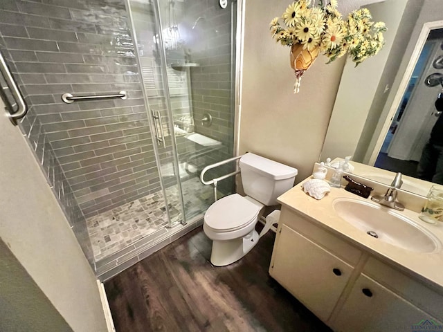 full bath featuring toilet, a shower stall, wood finished floors, and vanity