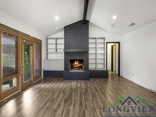 1204 Marigold Ln, Longview, TX 75604 - unfurnished living room with wood finished floors, built in shelves, and a brick fireplace