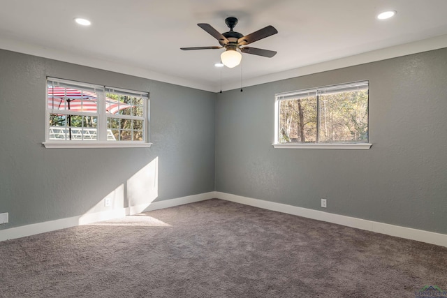 carpeted spare room featuring ceiling fan