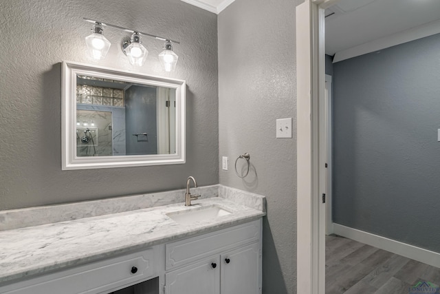 bathroom featuring hardwood / wood-style floors, vanity, and ornamental molding