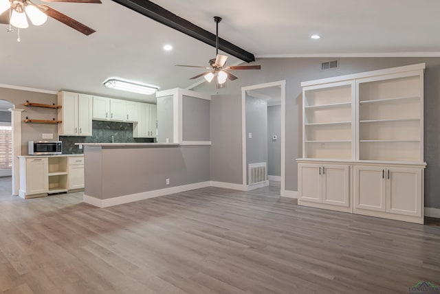 kitchen with ceiling fan, vaulted ceiling with beams, backsplash, light hardwood / wood-style floors, and white cabinets