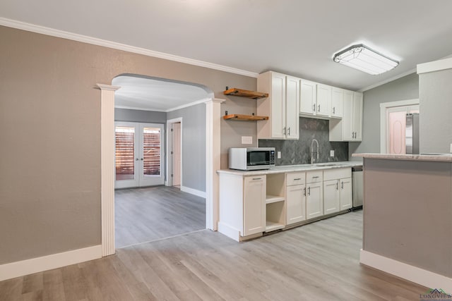 kitchen with tasteful backsplash, white cabinetry, stainless steel appliances, and french doors