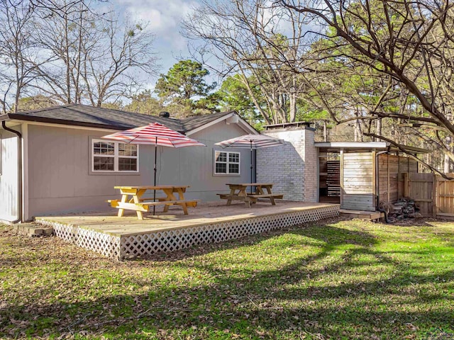 rear view of property featuring a wooden deck and a yard