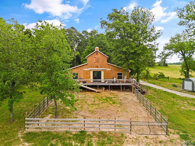 rear view of house featuring an outbuilding and a rural view