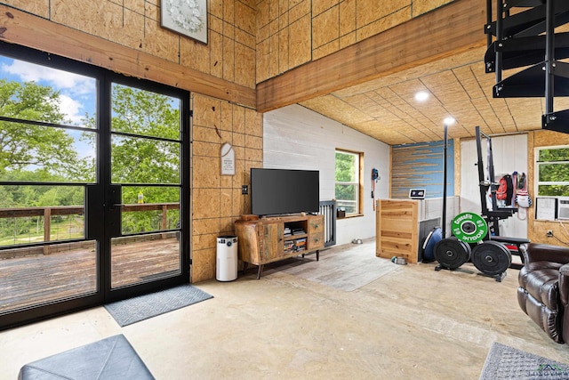 interior space with wooden walls, cooling unit, and lofted ceiling