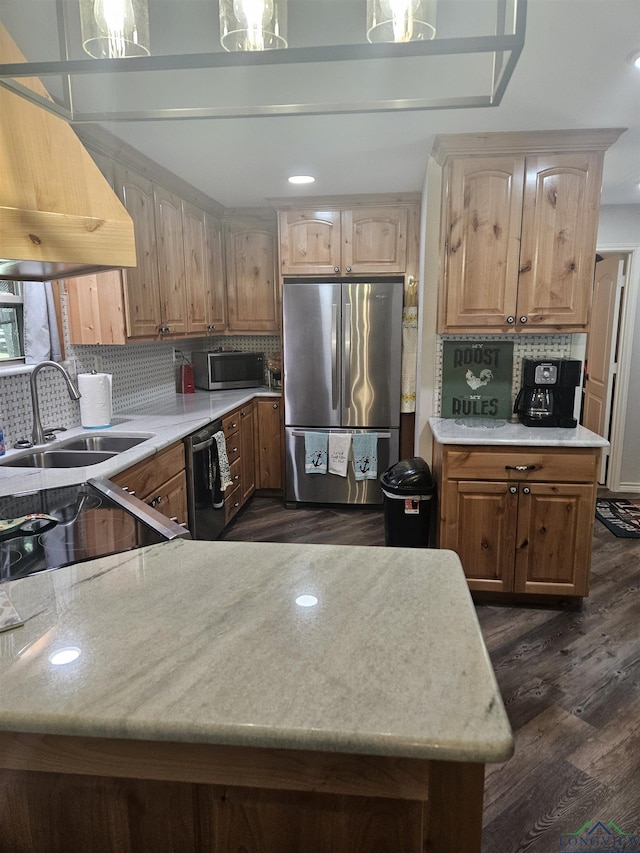 kitchen featuring stainless steel refrigerator, dishwasher, sink, range hood, and backsplash