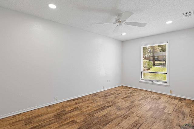 empty room with visible vents, baseboards, a ceiling fan, and wood finished floors