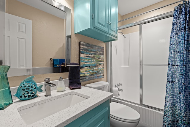 full bath with vanity, toilet, a textured wall, and combined bath / shower with glass door