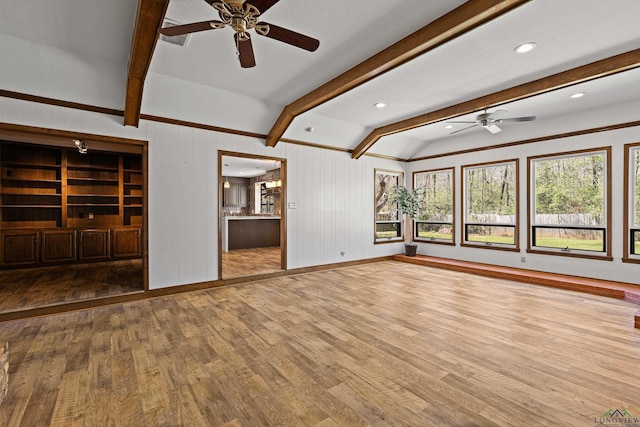 unfurnished living room with lofted ceiling with beams, baseboards, wood finished floors, and ceiling fan