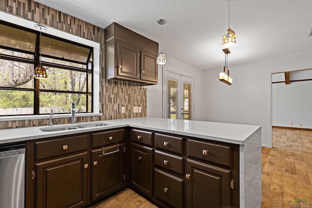 kitchen with dishwasher, dark brown cabinetry, backsplash, and a sink