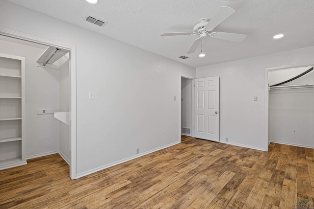 unfurnished bedroom featuring visible vents, a textured ceiling, and wood finished floors