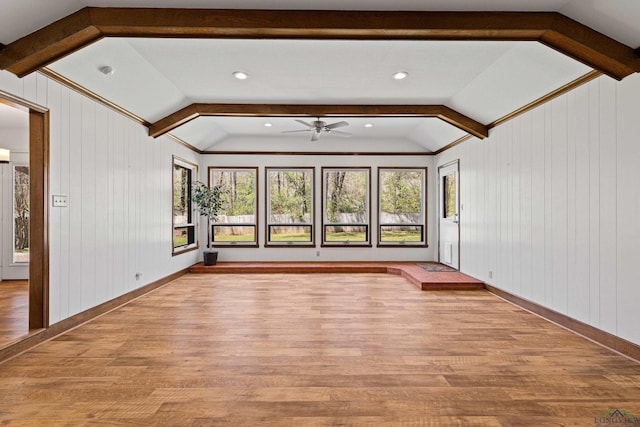 unfurnished room with a ceiling fan, wood finished floors, and vaulted ceiling with beams