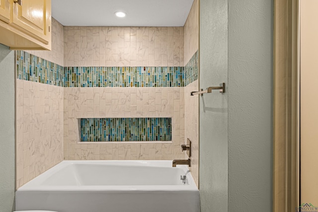 full bath featuring washtub / shower combination and a textured wall