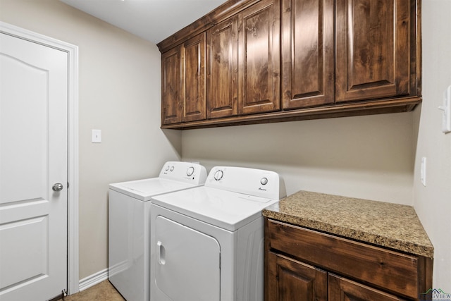 clothes washing area with washing machine and clothes dryer and cabinet space