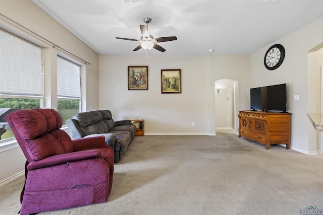 living room with arched walkways, visible vents, carpet, baseboards, and a ceiling fan