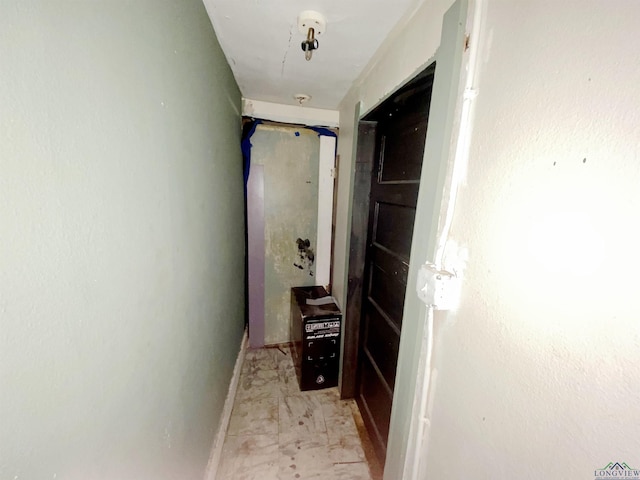 hallway featuring baseboards and marble finish floor