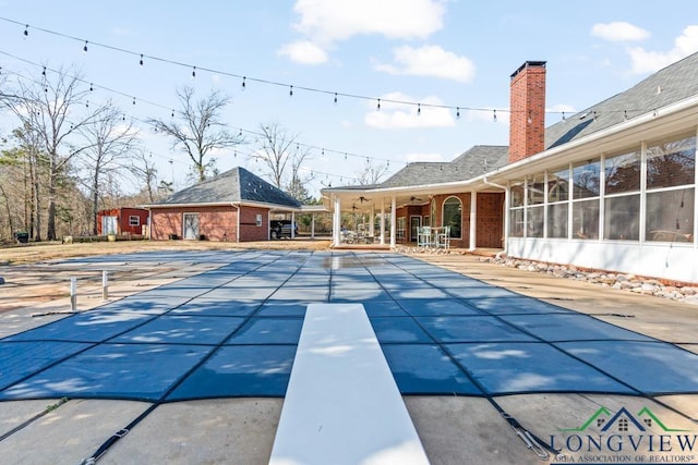 view of swimming pool with a diving board and a patio