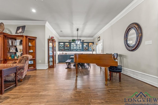 living area with a wealth of natural light, wood-type flooring, a chandelier, and ornamental molding