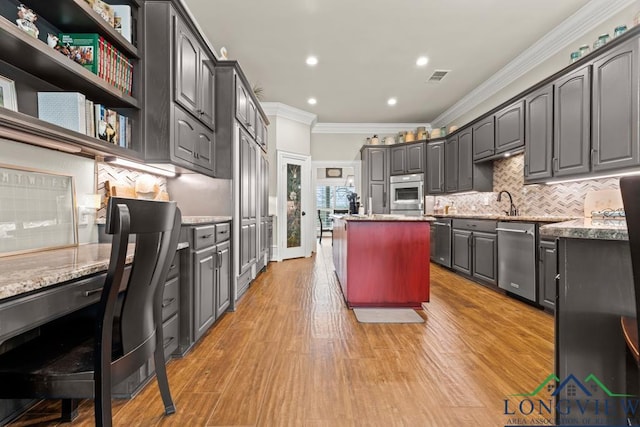 kitchen with light stone countertops, oven, dishwasher, built in desk, and decorative backsplash