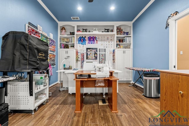 home office featuring ornamental molding, built in shelves, and wood-type flooring