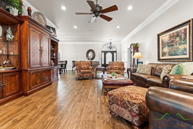 living room with ceiling fan, ornamental molding, and light hardwood / wood-style flooring