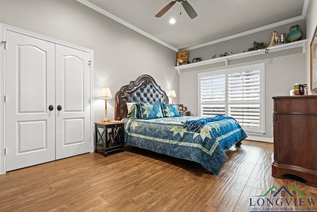 bedroom with hardwood / wood-style flooring, ornamental molding, and ceiling fan