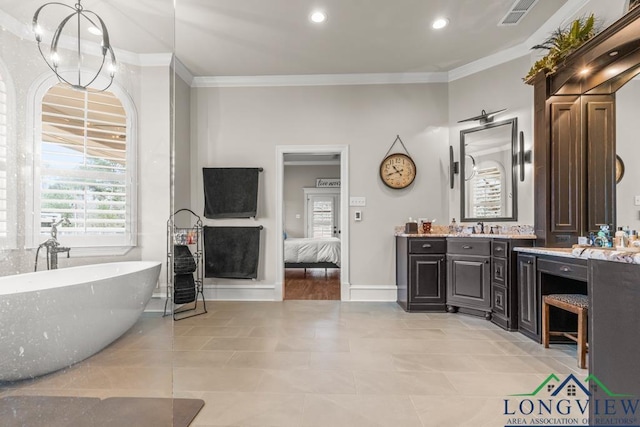 bathroom featuring ornamental molding, a bathing tub, vanity, and tile patterned floors