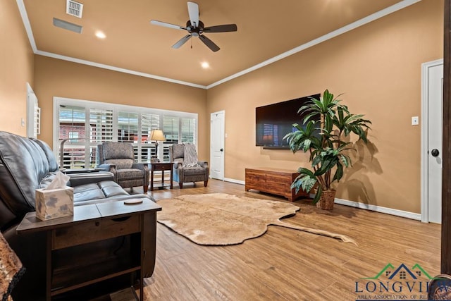 living room with light hardwood / wood-style floors, ceiling fan, and ornamental molding