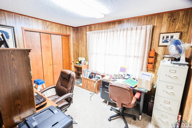 carpeted office space featuring a textured ceiling and wooden walls