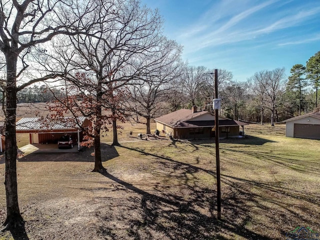 view of yard featuring an outdoor structure and a carport