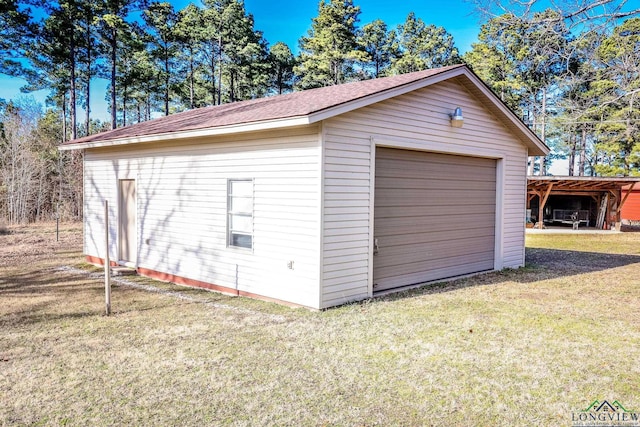 garage with a carport and a lawn