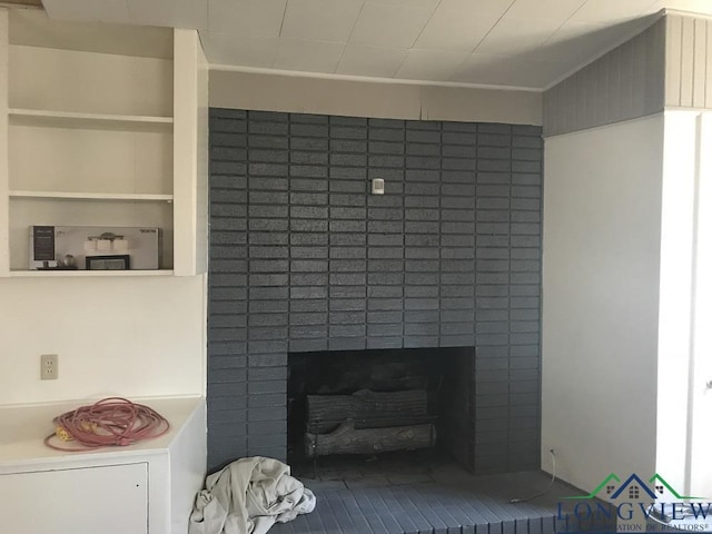 interior details featuring built in features and a brick fireplace