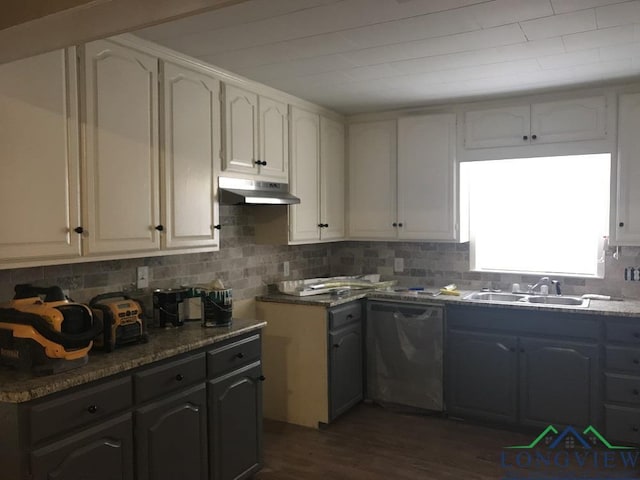 kitchen with dark hardwood / wood-style flooring, sink, dark stone countertops, black dishwasher, and white cabinetry