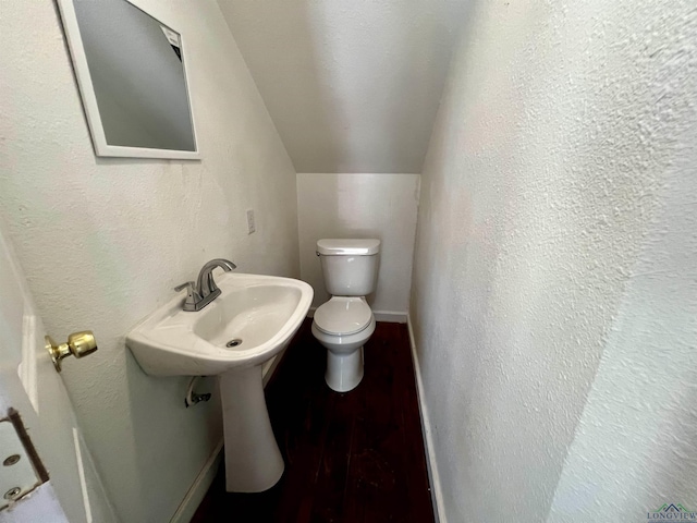 bathroom featuring toilet and lofted ceiling