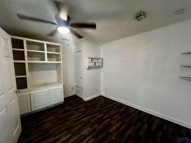 spare room featuring dark hardwood / wood-style floors, ceiling fan, an AC wall unit, and a textured ceiling