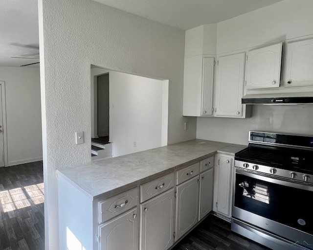 kitchen featuring dark hardwood / wood-style flooring, ceiling fan, stainless steel range, and white cabinets