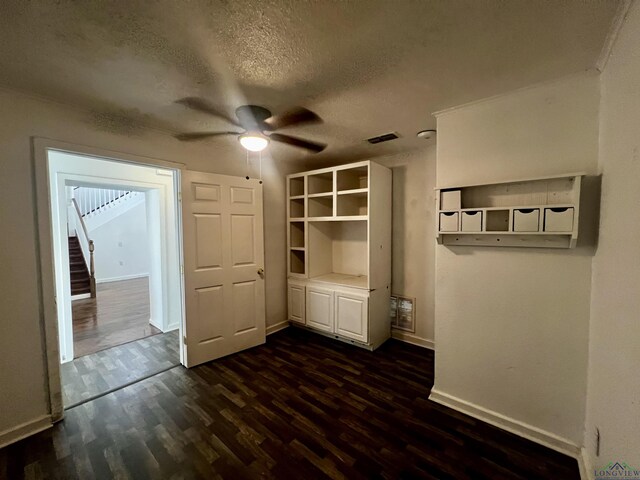 interior space featuring ceiling fan, dark hardwood / wood-style flooring, and a textured ceiling