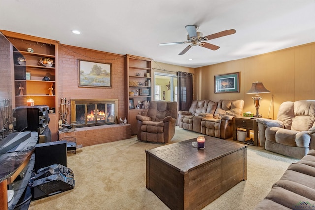 carpeted living room with built in shelves, ceiling fan, and a fireplace