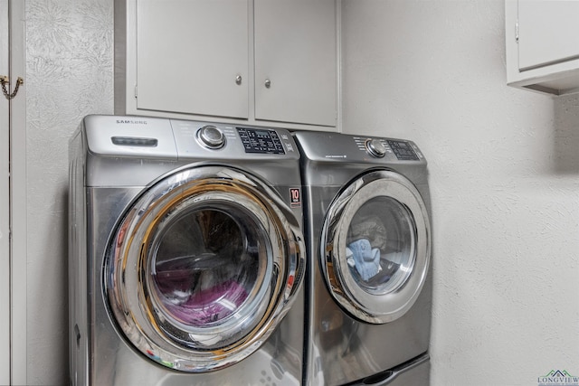 washroom featuring cabinets and washing machine and dryer