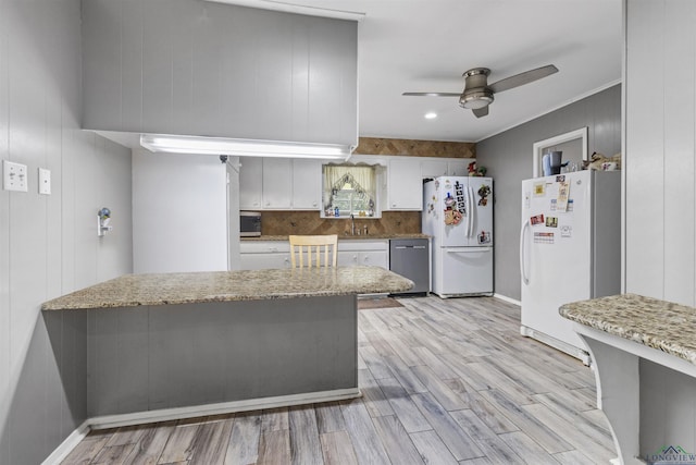 kitchen featuring dishwasher, white refrigerator, and kitchen peninsula