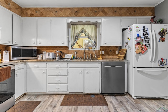 kitchen with backsplash, dark stone counters, white cabinets, sink, and stainless steel appliances