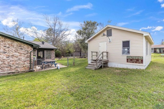 rear view of house with a patio and a lawn