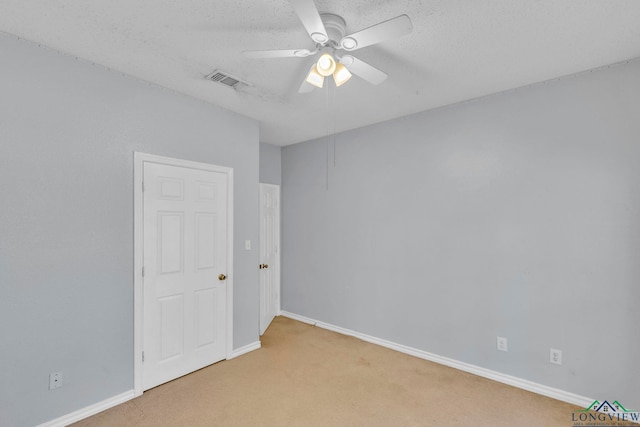 unfurnished room featuring visible vents, a ceiling fan, light carpet, a textured ceiling, and baseboards