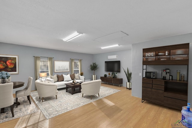 living area with a textured ceiling and light wood finished floors