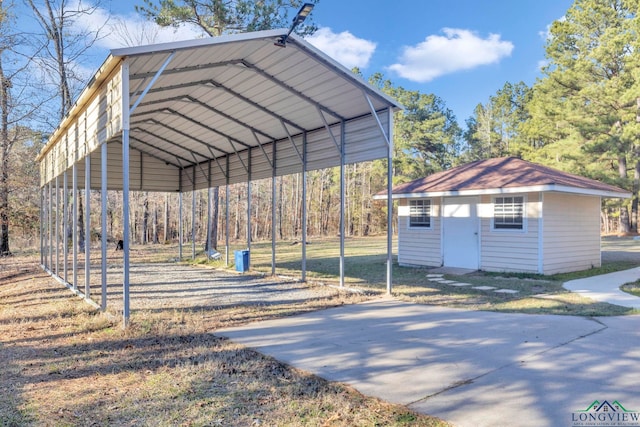 view of community featuring a detached carport, driveway, and an outdoor structure